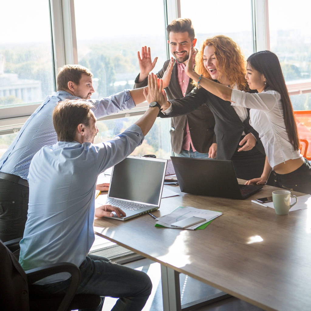 happy clients and team giving a group high 5 across a table